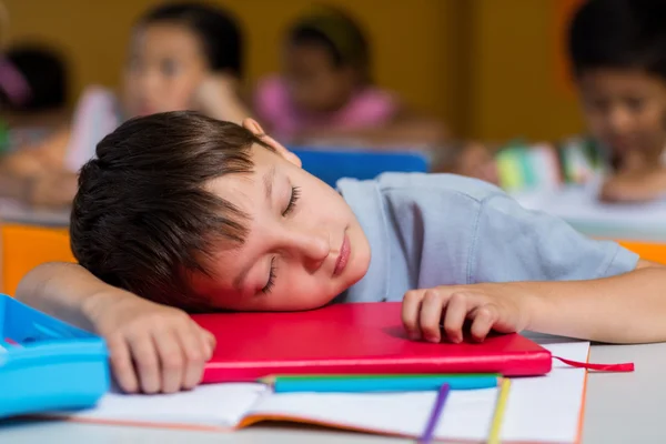 Carino ragazzo dormire su scrivania — Foto Stock