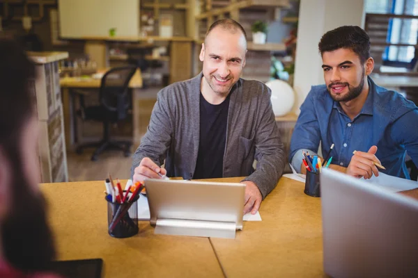 Business people smiling while talking at desk — Stock Photo, Image