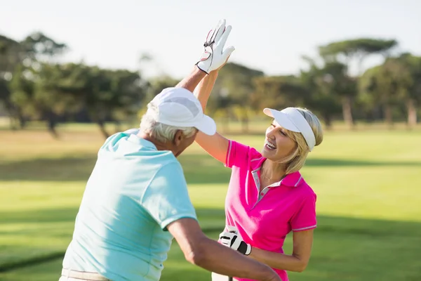 Alegre golfista casal dando alta cinco — Fotografia de Stock