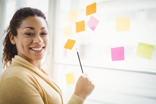 Businesswoman writing on adhesive notes — Stock Photo, Image