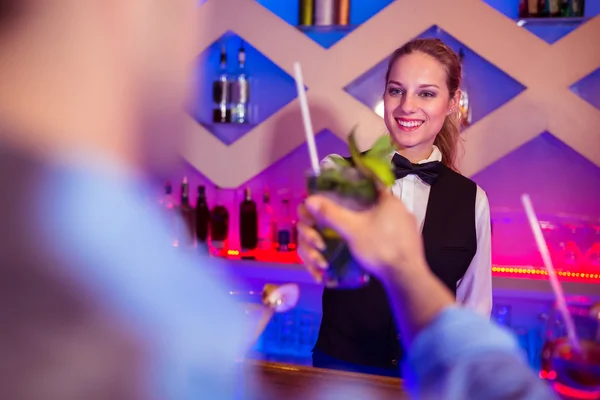 Barmaid serving drink to male costumer — Stock Photo, Image