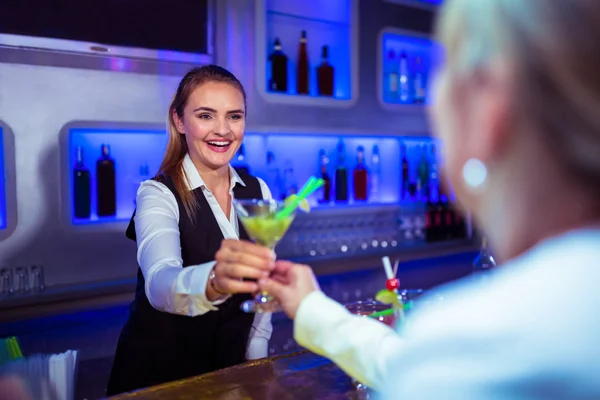 Bartender serving cocktail to woman — Stock Photo, Image