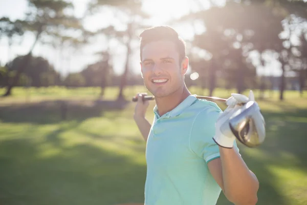Young man carrying golf club — Stock Photo, Image