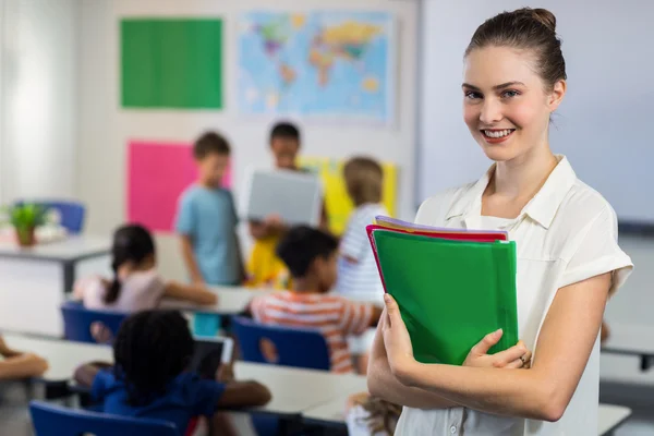 Kvinnlig lärare med filer som står i klassrummet — Stockfoto