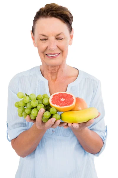 Happy mature woman holding fruits — Stock Photo, Image