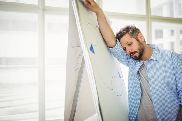 Homme d'affaires fatigué appuyé sur le tableau blanc — Photo