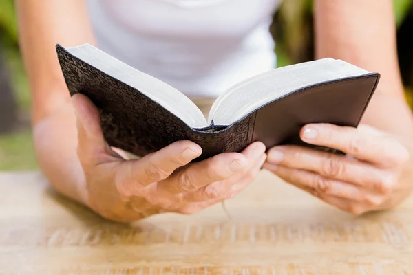 Frau liest Bibel am Tisch — Stockfoto