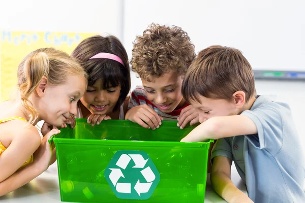Crianças olhando para garrafas em caixa de reciclagem — Fotografia de Stock