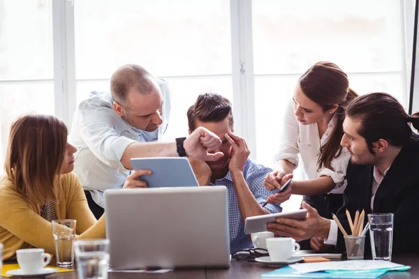 Frustrated businessman in between coworkers — Stock Photo, Image