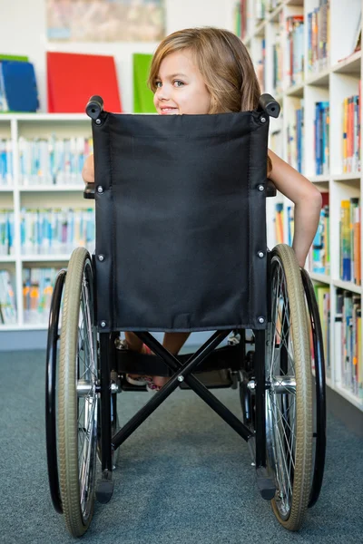 Ragazza handicappata alla biblioteca della scuola — Foto Stock