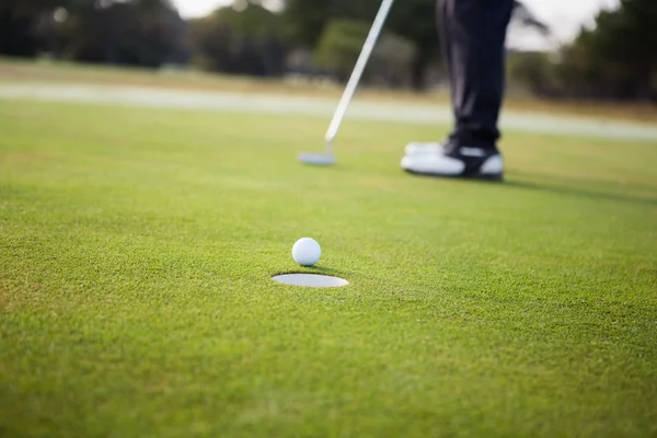 Крупный план мяча для гольфа и лунки Стоковое Фото