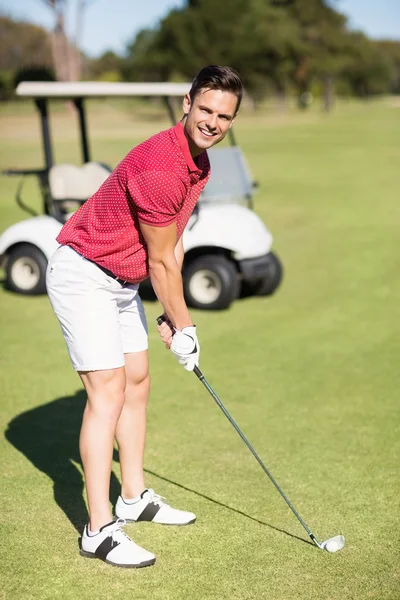Улыбающийся молодой человек, играющий в гольф — стоковое фото