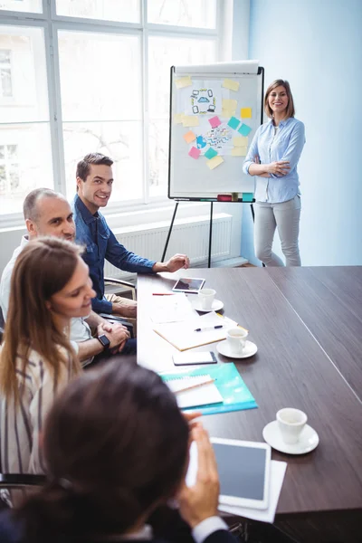 Empresária com colegas de trabalho na sala de reuniões — Fotografia de Stock