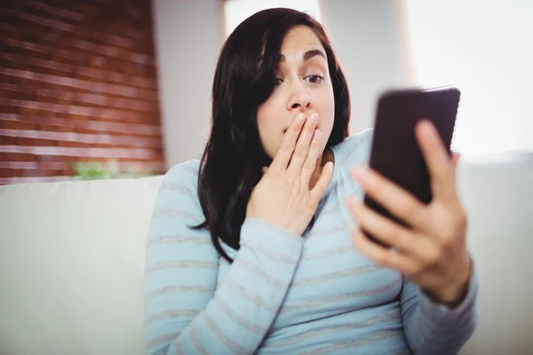 Chockad kvinna med mobiltelefon — Stockfoto