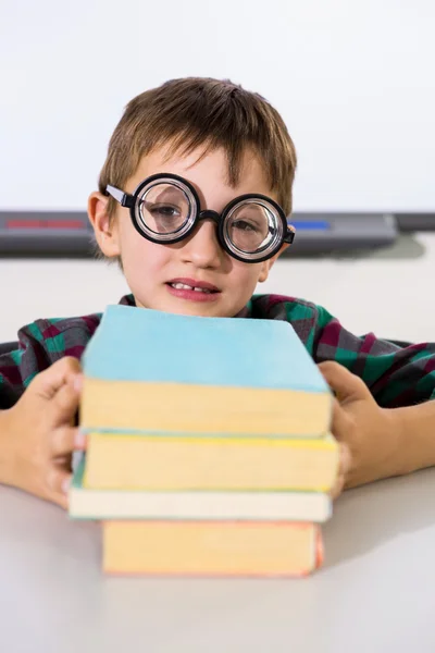 Niño sosteniendo libros en la mesa — Foto de Stock