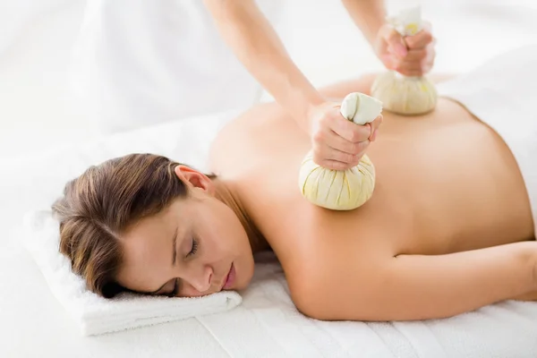 Woman receiving herbal compress massage — Stock Photo, Image