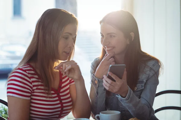 Kobieta pokazując telefon do przyjaciela w kawiarni — Zdjęcie stockowe