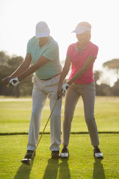 Mature male golf player teaching woman — Stock Photo, Image