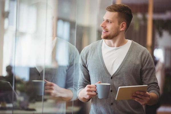 Businessman holding coffee cup with tablet — Stock Photo, Image