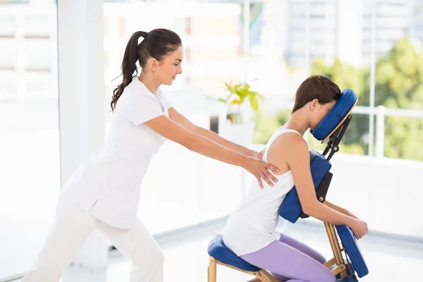Donna essere massaggiato su sedia da massaggiatrice — Foto Stock