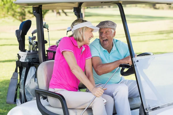 Couple sitting in golf buggy — Stock Photo, Image