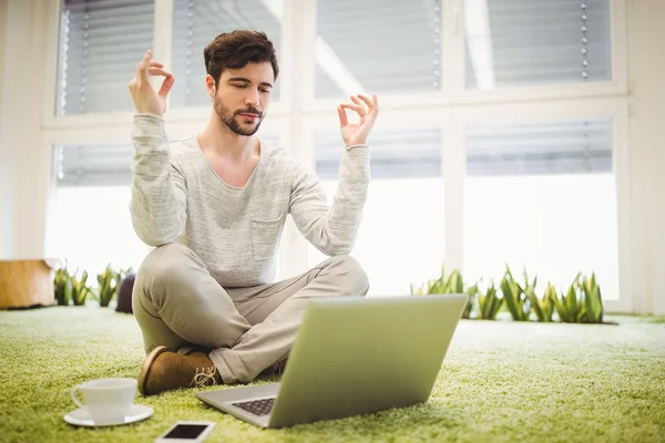 Affärsman gör yoga framför laptop — Stockfoto