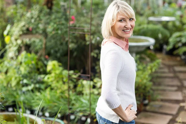 Vrouw met hand op heup op broeikasgassen — Stockfoto