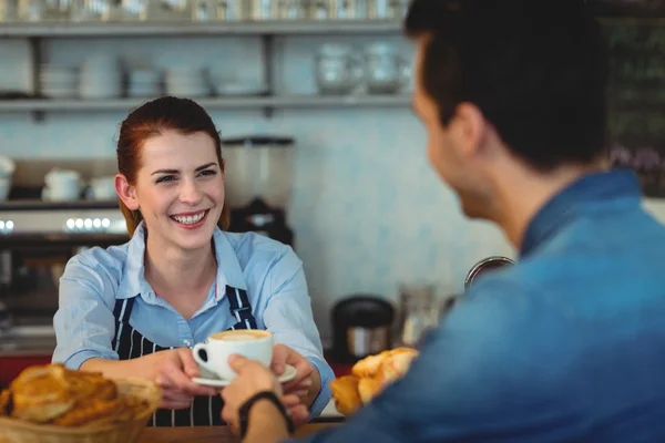 Barista давая кофе клиенту в столовой — стоковое фото