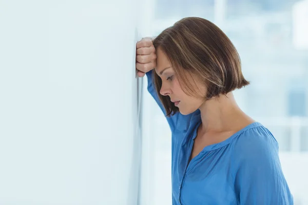 Sidovy av ledsen kvinna av vägg — Stockfoto