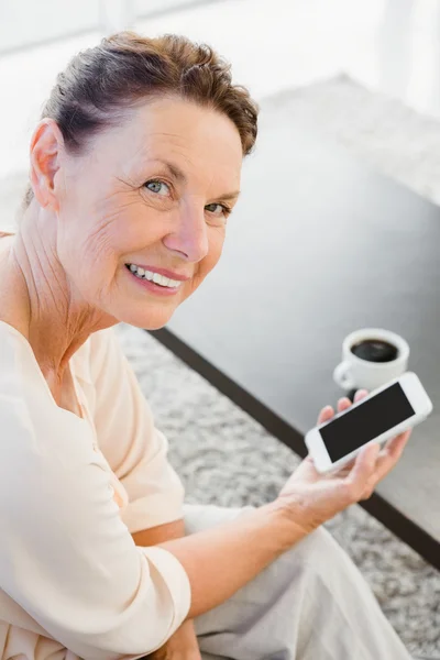 Volwassen vrouw die een smartphone vasthoudt — Stockfoto