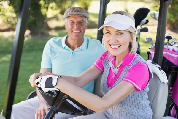 Mature couple sitting in golf buggy — Stock Photo, Image