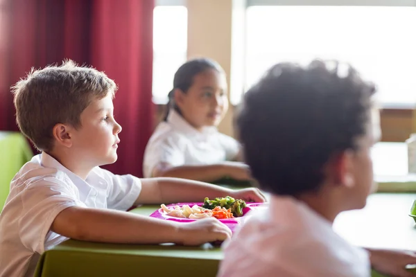 Ragazzo con compagni di classe in mensa — Foto Stock