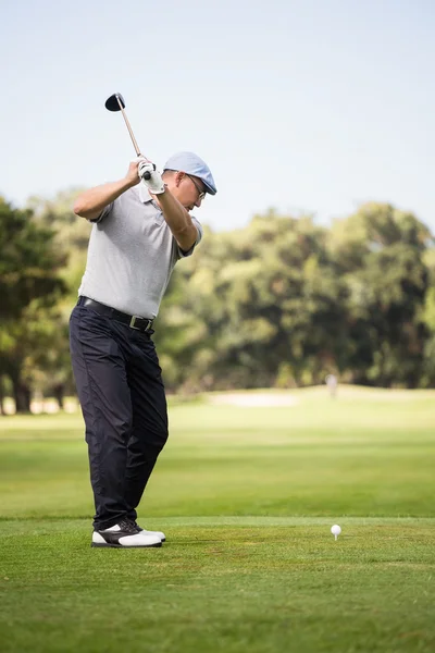 Homem que joga golfe enquanto está em campo — Fotografia de Stock