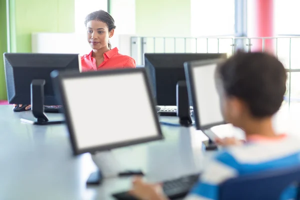 Teacher using computer in classroom — Stock Photo, Image