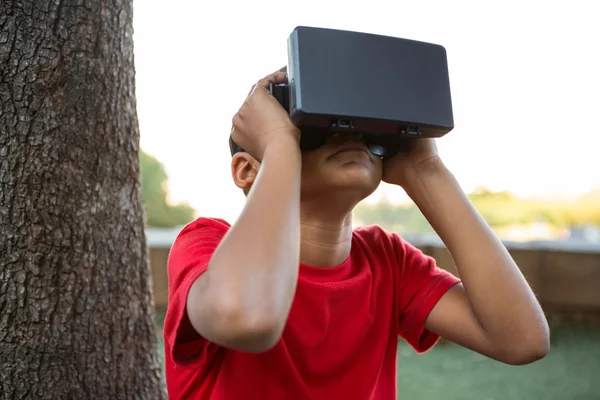 Menino elementar usando fone de ouvido de realidade virtual — Fotografia de Stock