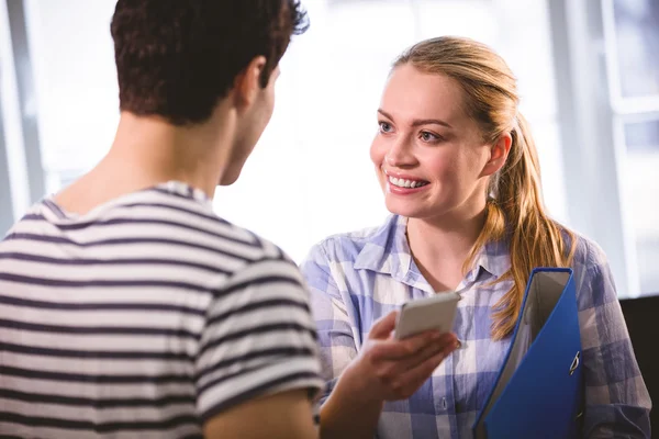 Verkställande med mobiltelefon tittar på kollega — Stockfoto