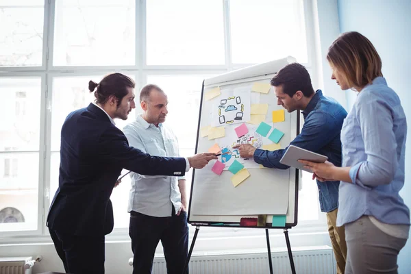 Kollegen zeigen auf Whiteboard — Stockfoto