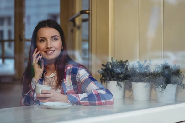 Kvinna som lyssnar på mobiltelefon på café — Stockfoto