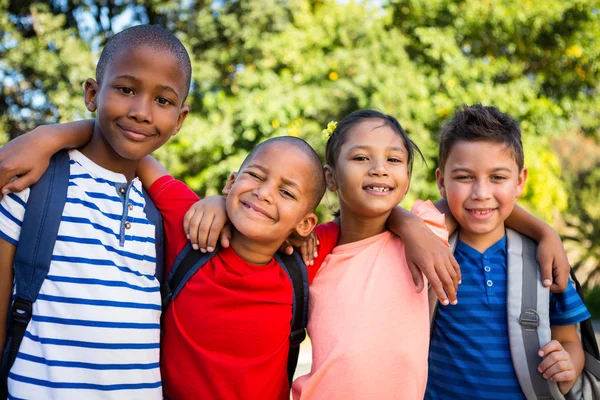 Klasskamrater med armar runt på skolan campus — Stockfoto