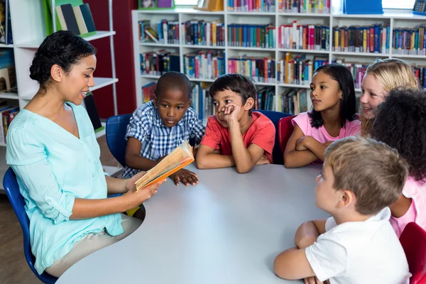 Lehrerin liest Kindern ein Buch vor — Stockfoto