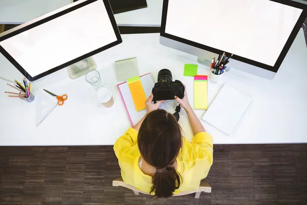 Profi sitzt mit Kamera am Schreibtisch — Stockfoto