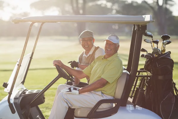 Golfer friends sitting in golf buggy — Stock Photo, Image