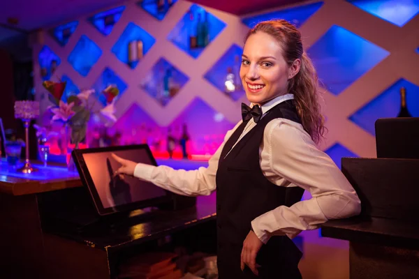 Barmaid pointing at modern cash register — Stock Photo, Image