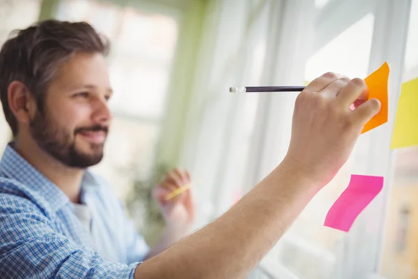 Empresario escribiendo en notas adhesivas — Foto de Stock