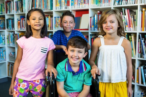 Handicapped ragazzo con amici in biblioteca — Foto Stock