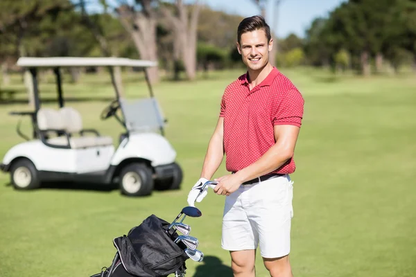 Улыбающийся мужчина с клюшкой для гольфа — стоковое фото