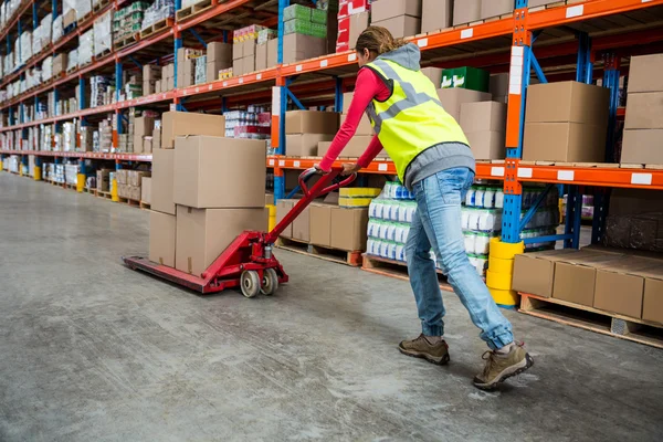 Worker pushing trolley with boxes — Stock Photo, Image