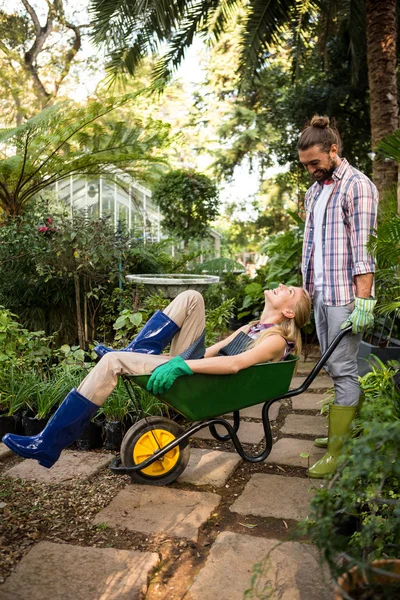 Colegas desfrutando com carrinho de mão no jardim — Fotografia de Stock