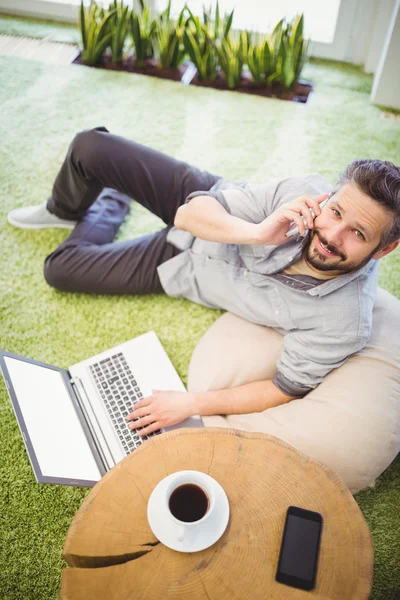 Affärsman med laptop och telefon — Stockfoto