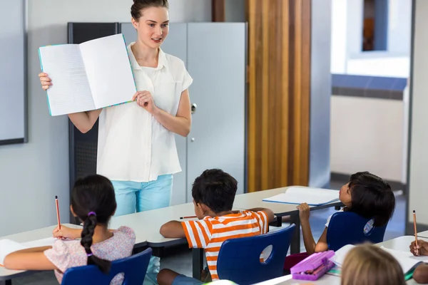 Profesor mostrando libro con niños —  Fotos de Stock